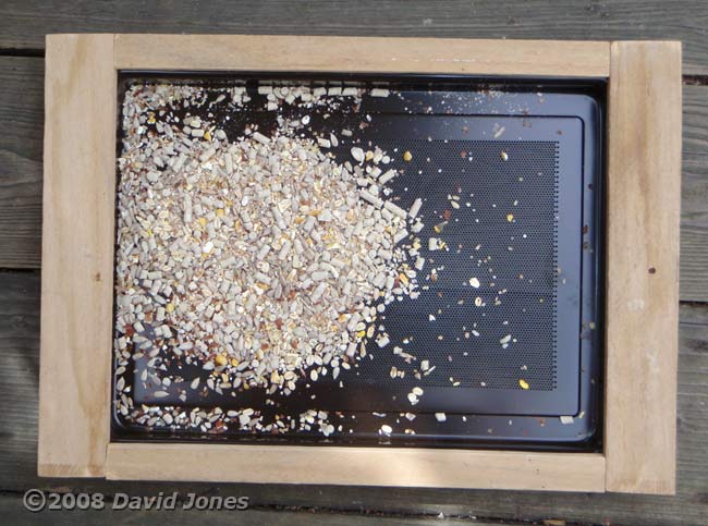 Old microwave door panel becomes a bird table top