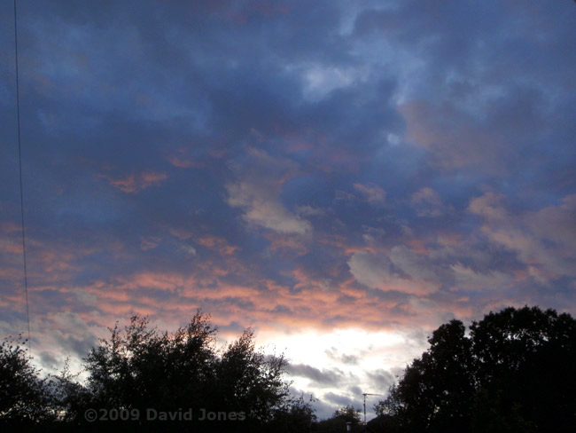 A bit of brightness sneaks under the clouds at sunset